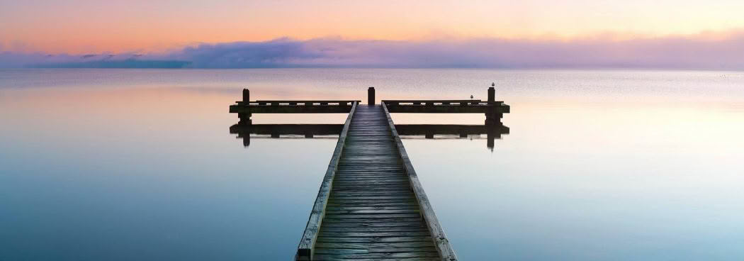 A jetty at sunrise on a calm Lake Rotorua, Lake Rotorua, New Zealand