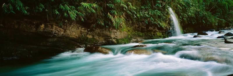 Sublime. Annapurna Himalayan Range, Nepal. A waterfall drops into a rushing river on the Annapurna circuit.