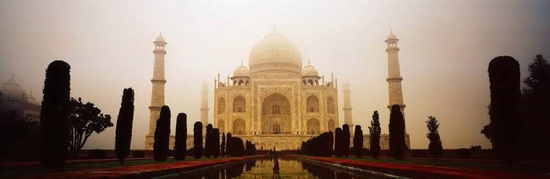 The Taj Mahal in panoramic form with fog and the pool in the foreground
