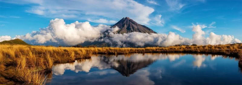 Mt Taranaki, New Zealand. Mount Taranaki reflected in a tarn as the dusk light illuminates the scene