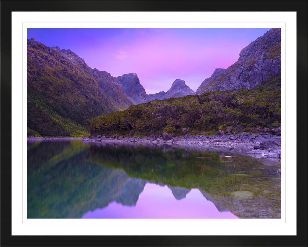 New Zealand Landscape Photography Lake Mackenzie on the Routeburn Track. Dawn pink light of mountains reflected in lake.