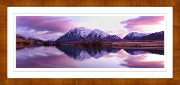 Landscape photography of New Zealand. Lake in Canterbury at dawn with pink sky and reflection of snow capped mountains