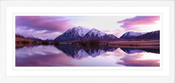 Landscape photography of New Zealand. Lake in Canterbury at dawn with pink sky and reflection of snow capped mountains