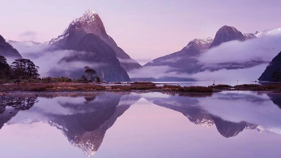Milford Sound at dawn with clouds reflected in the water