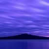 Rangitoto Island at dawn with textured clouds and sunrise light throughout photograph
