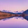 Small lake in Canterbury reflecting snow-capped Southern Alps at dawn