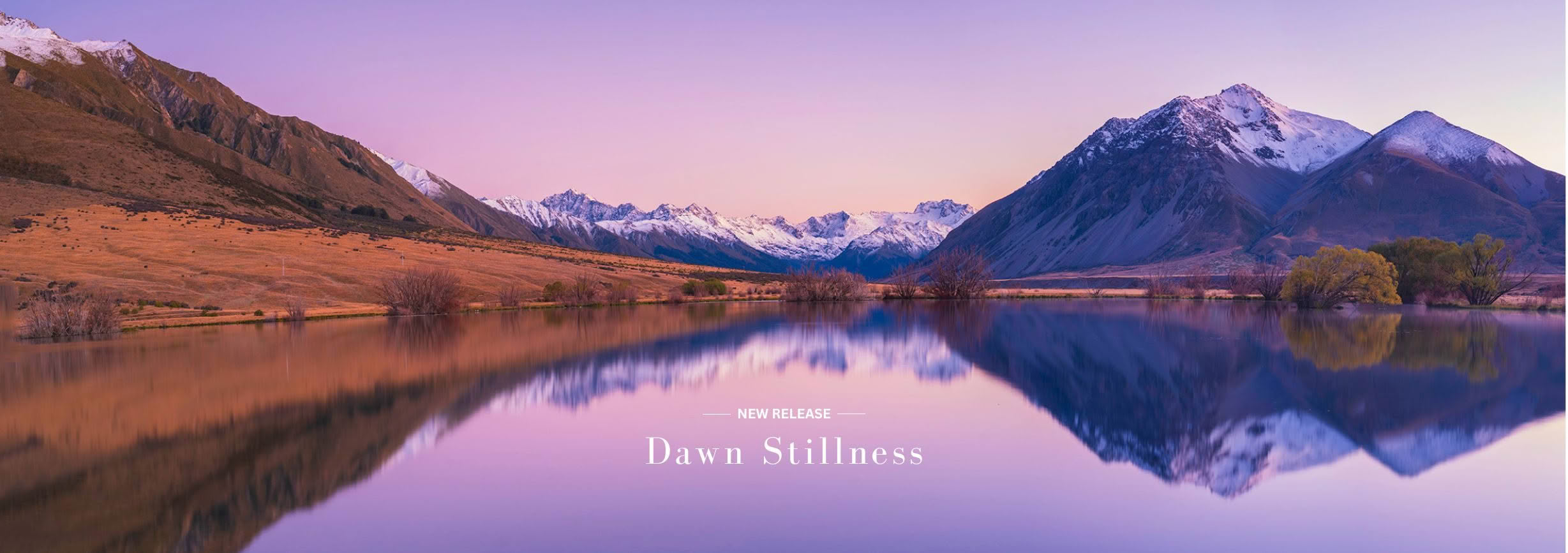 Small lake in Canterbury reflecting snow-capped Southern Alps at dawn