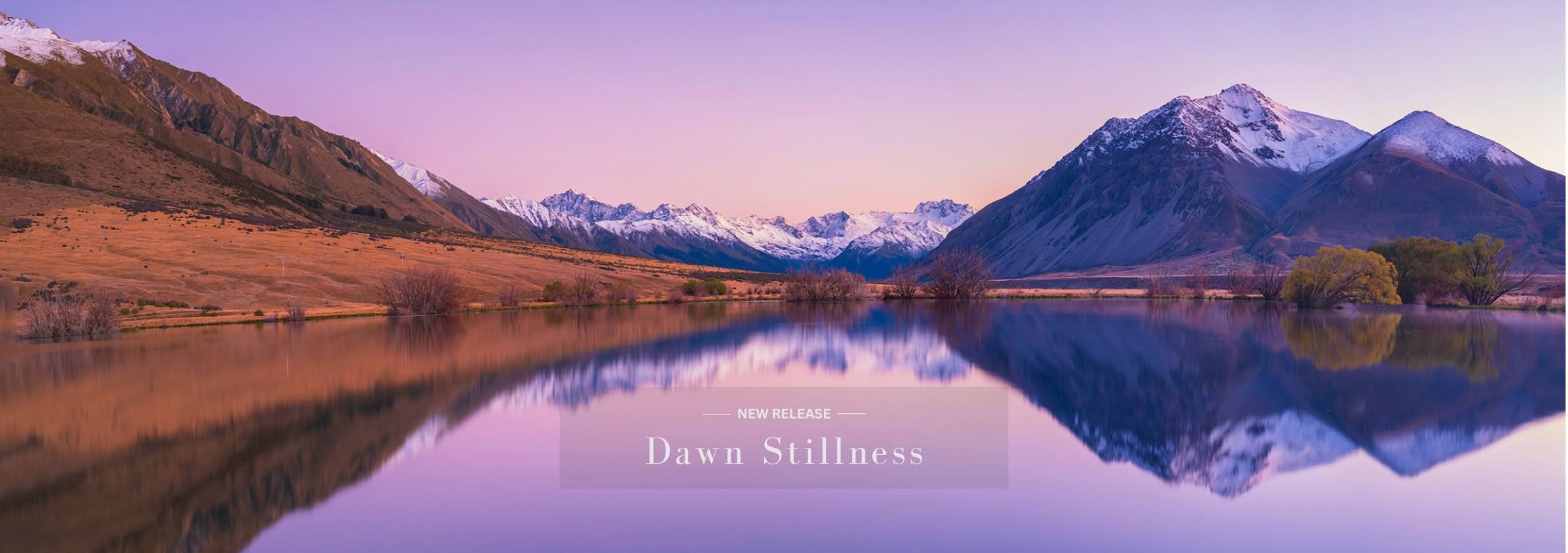 Small lake in Canterbury reflecting snow-capped Southern Alps at dawn
