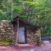Sam Summers Hut, a historic stone gold miners' hut surrounded by native beech forest near Queenstown, Otago, New Zealand.